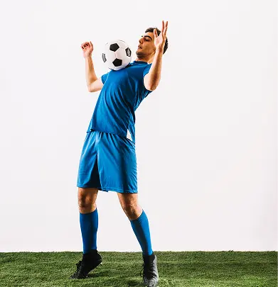 Um atleta de futebol executa uma técnica de controlo de peito, demonstrando equilíbrio, coordenação e habilidades essenciais de manuseio da bola usadas em jogos competitivos.
